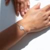Modelo con pulsera corazón personalizada de plata y cadena de eslabones ovalados