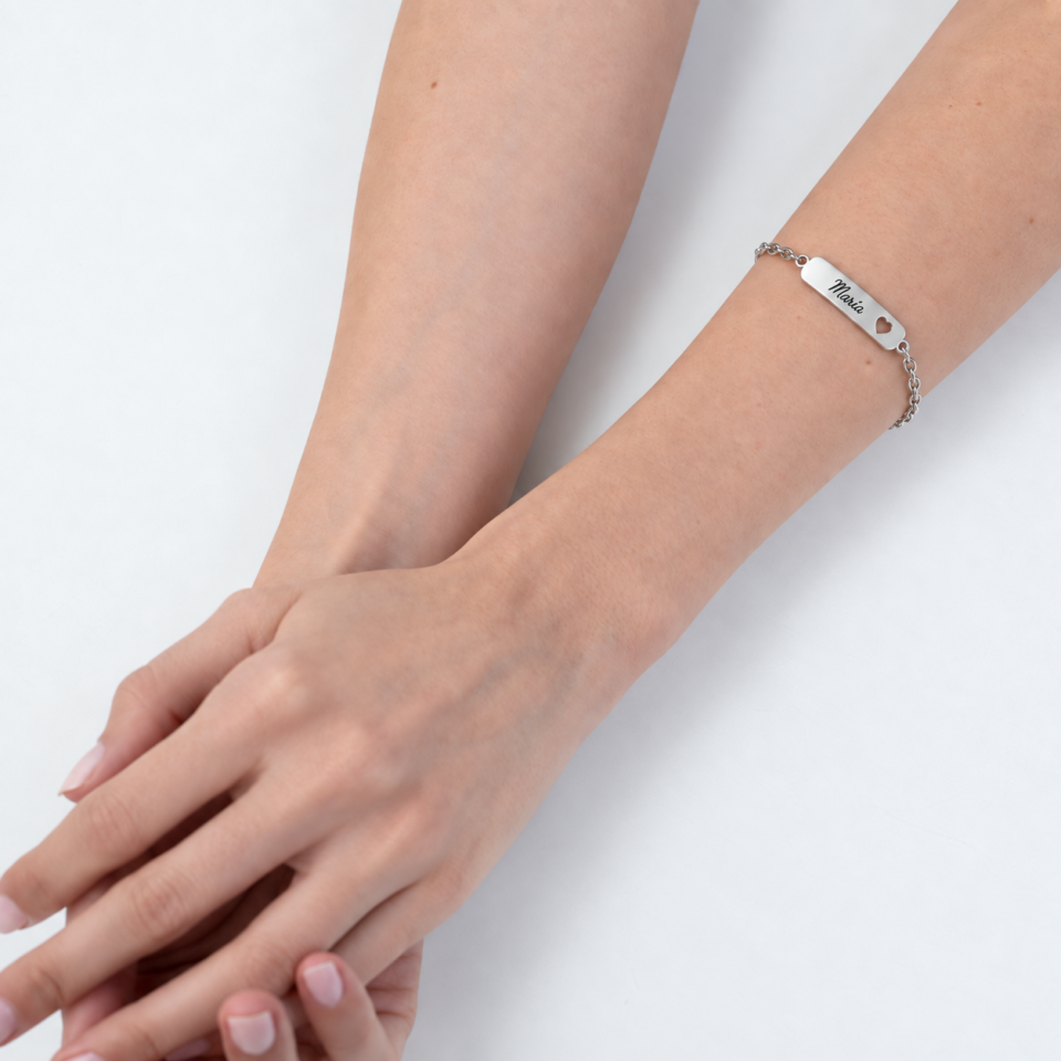 Modelo con pulsera placa corazón calado personalizada de plata y cadena de eslabones ovalados