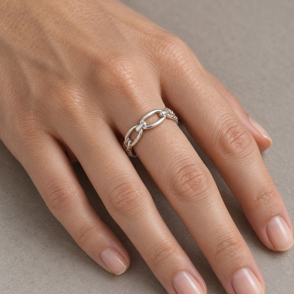 Anillo de plata de ley con eslabones ovalados y brazo barbado puesto en la mano