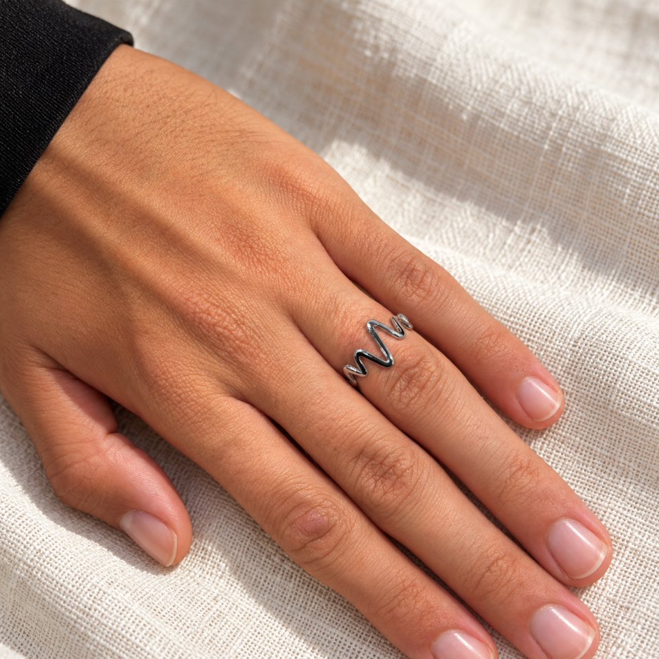 Anillo fino electro de plata de ley 925 sobre un dedo, con zigzag longitudinal y aro cerrado
