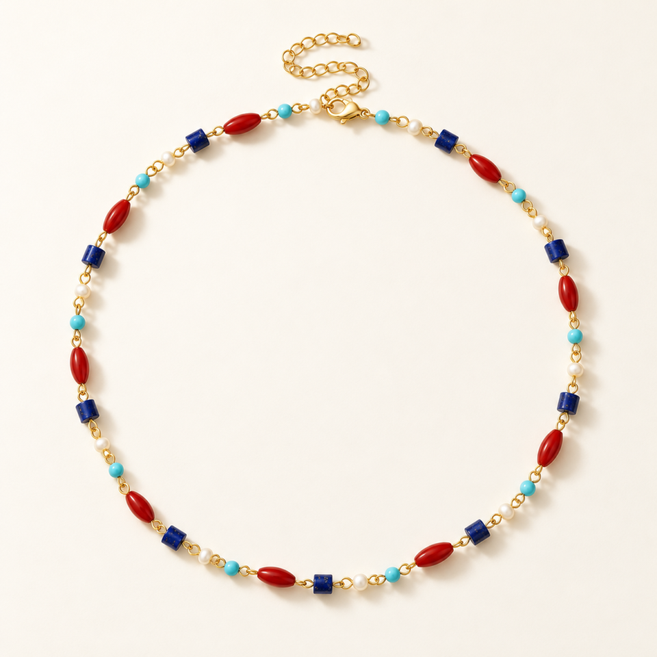 Collar Atlántico dorado con cuentas rojas, azules, turquesa y blancas sobre fondo marfil